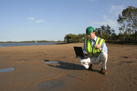 Scientist on lake shore testing water quality Scientist on lake shore testing water quality